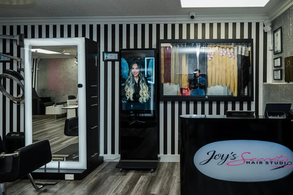 Stylist working on client's hair at Joy's Secrets